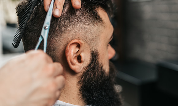 Total Hair Restoration barber cutting hair