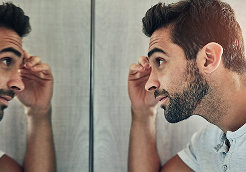 Total Hair Restoration man looking into mirror